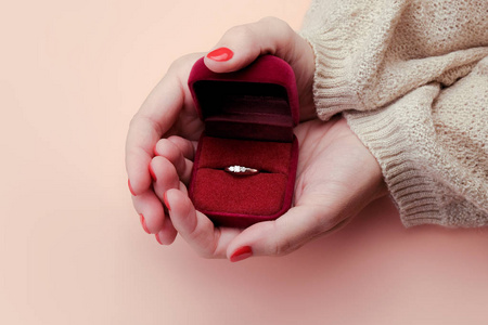 显示结婚戒指女人的手拿着一个装有结婚戒指的盒子.照片