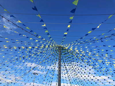 一排装饰小旗在深蓝色的天空背景下迎风飘扬谷物彩旗男性的唱歌向一树