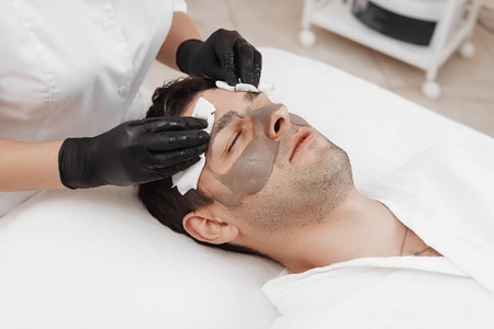美容师在spa沙龙为男士敷面膜.照片