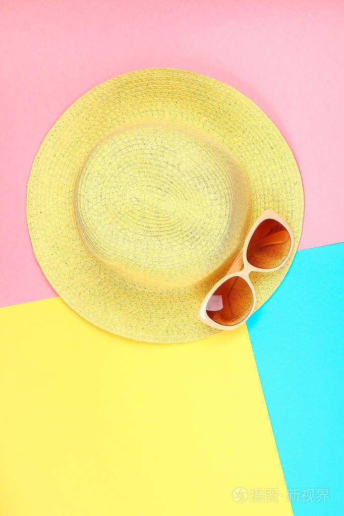 帽子太阳镜上有蓝黄粉红三色粉彩背景。