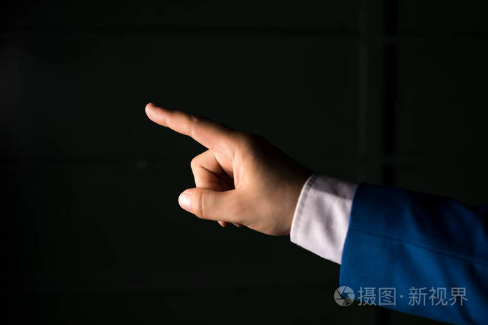 单独用手指指向复制空间.商业概念与指手画脚.黑色背景上方的孤立手.