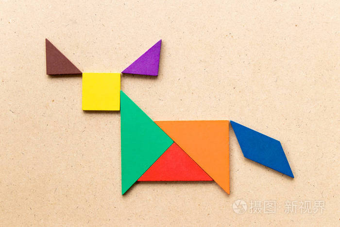 彩色七巧板形状为牛水牛或公牛在木头背景上