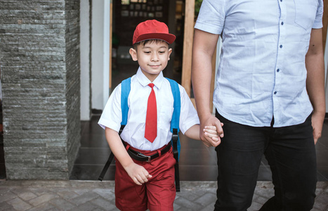 父亲带着他的小学生儿子去上学图片