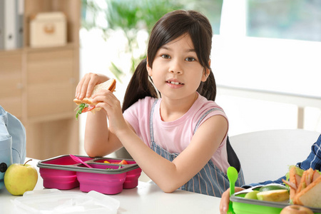 学童在教室里吃午饭小学生在教室里吃午饭学生们在休息的时候在教室里