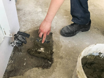 建筑工人用金属抹刀将墙面抹上灰泥,用灰泥,瓷砖胶,水泥浇灌找平层