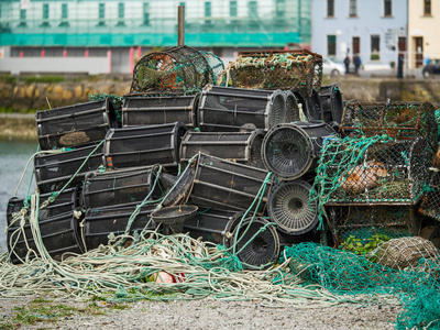 陷阱堆积堆积的空鱼圈,选择性聚焦,背景是城镇房屋,照片