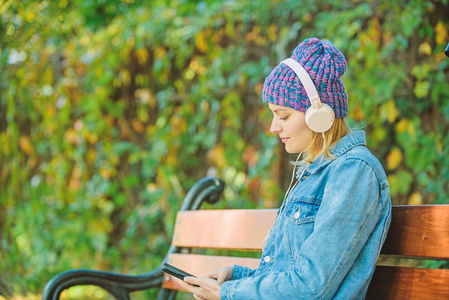 在公园里听音乐.现代科技代替阅读.戴耳机的时髦女人.有声照片