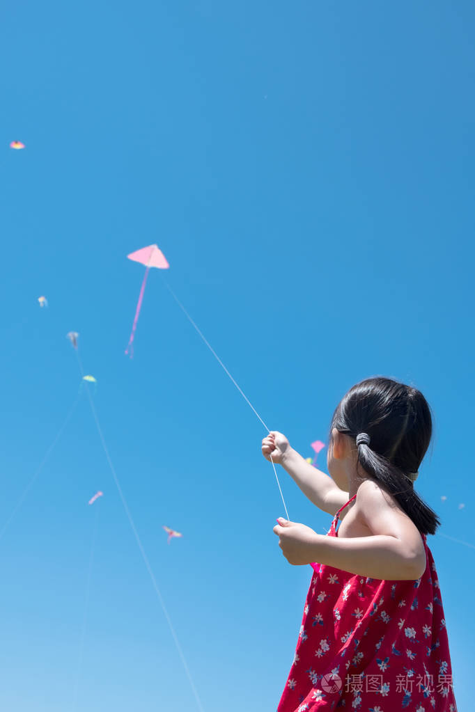 在阳光明媚的夏日里放风筝的小女孩