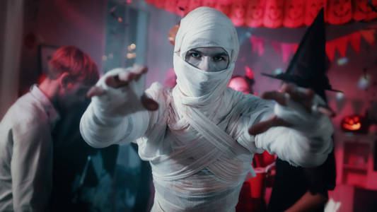 在背景僵尸,死亡,女巫和她魔鬼在一个怪物聚会装饰的房间里玩得照片