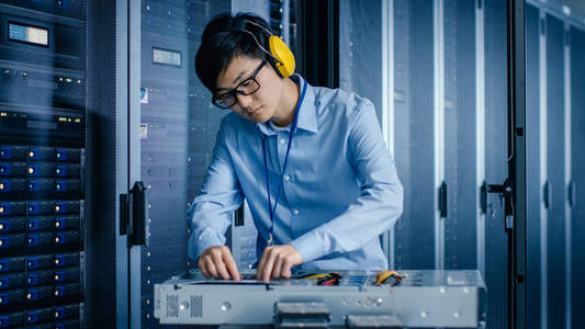 在现代数据中心:it工程师戴着防护罩为服务器机架安装新的硬件.