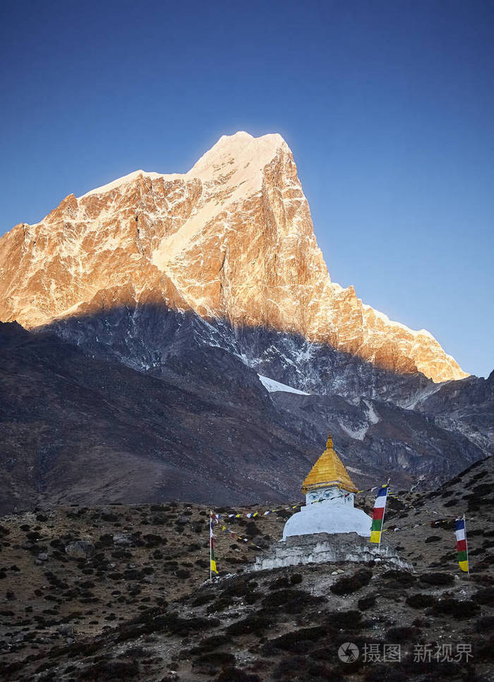 尼泊尔丁伯切村附近日出的佛塔悬挂着经幡和康特加山和塔姆塞尔库山