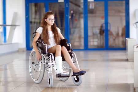 一个坐轮椅的小女孩站在医院的走廊上照片