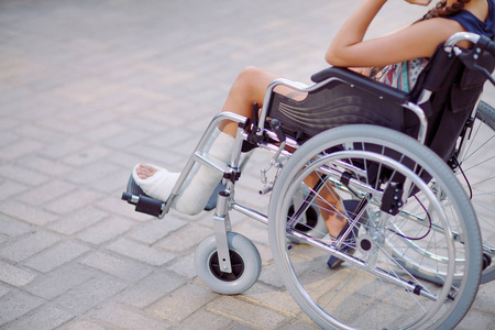 一个腿断了的女孩坐在轮椅上照片