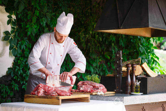 在一家餐馆里一个厨师用刀切肉