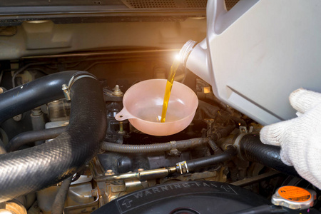 换机油汽车修理工正在使用发动机油箱.换机油.照片