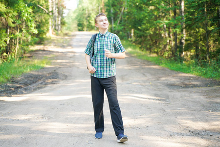 独自漫步夏日独自在森林里散步的少年男孩照片