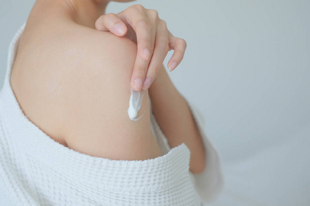 女性涂抹护臂霜,乳液,卫生护肤品,身体护理理念照片