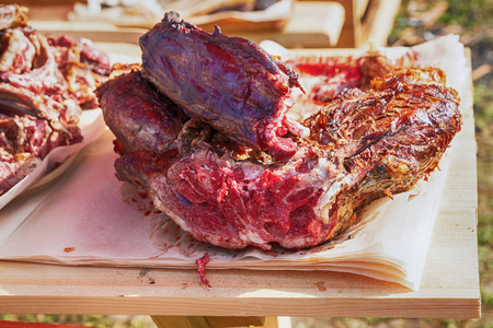 野生动物肉鹿肉在明火上煎的一大块,中间有红色的切块照片