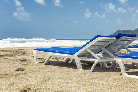 海边床海边公共沙滩上的白色躺椅和蓝色床垫.特写.文本空间.照片