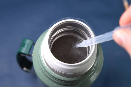 液态空气,将液化空气倒入保温瓶.照片