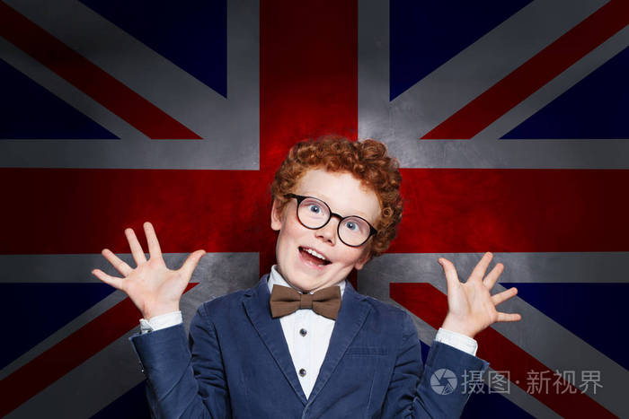 英国国旗背景下滑稽调皮的男孩学生