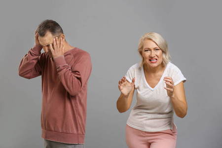 中年女性吵架灰色背景下吵架的中年夫妇照片