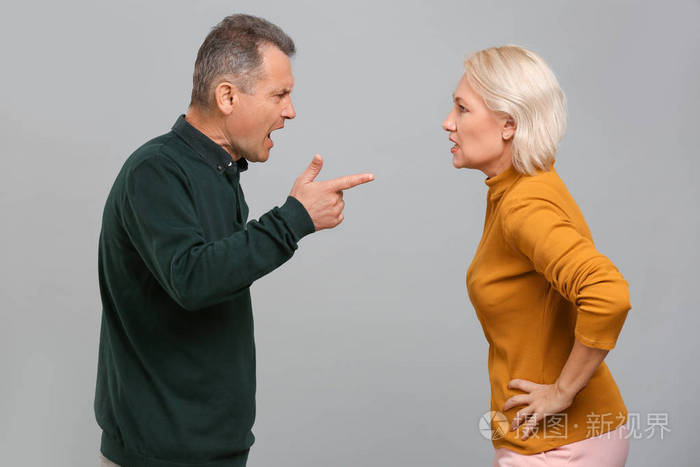 灰色背景下吵架的中年夫妇