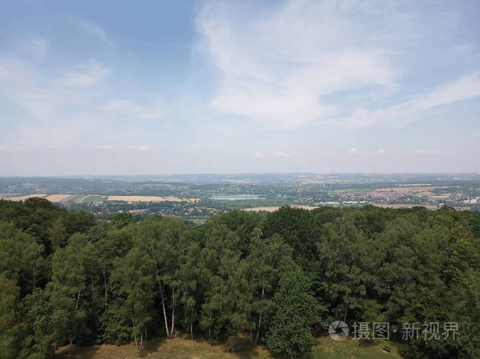 城市田野和森林的俯视图晴朗的一天云彩和蓝天有各种建筑的丘陵地区