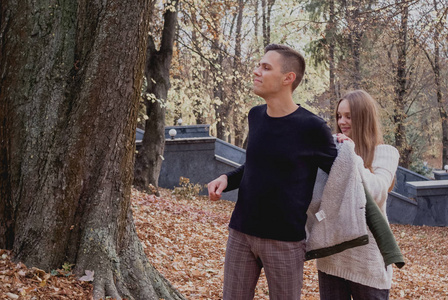 享受美丽的秋日一对相爱的情侣站在公园里秋天的落叶上,享受着美丽的