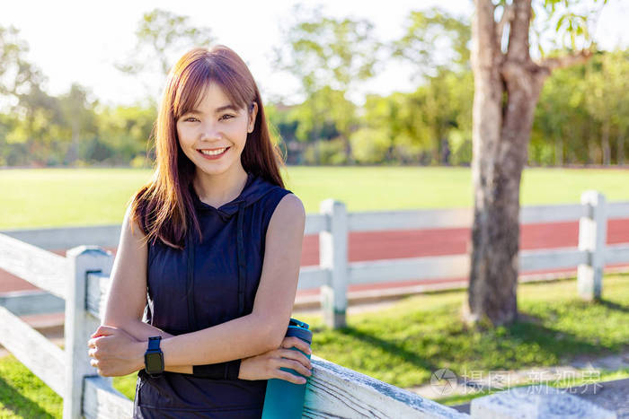 快乐美丽的亚洲年轻女子微笑着面对镜头在一个阳光明媚的早晨站在户外