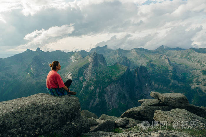 坐在山上的女人有着美丽的自然背景