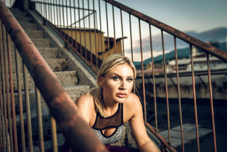 坐在屋顶楼梯上的健身妇女图片