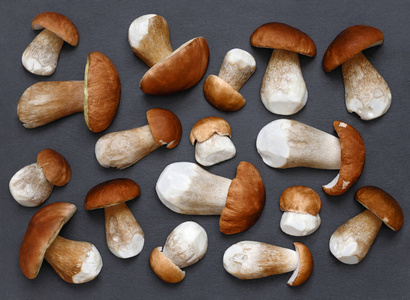 在灰色的石头砧板上剥皮的新鲜蘑菇.蘑菇背景.照片