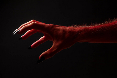 黑色背景上红色魔鬼恐怖的万圣节手照片