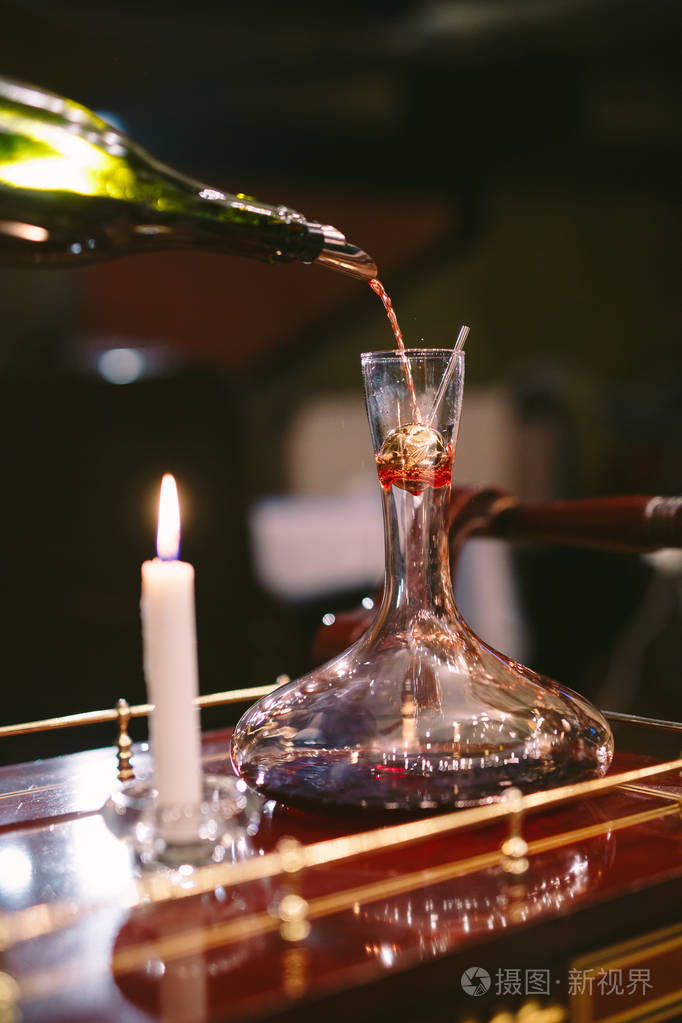 斟酒师把红酒倒入醒酒器