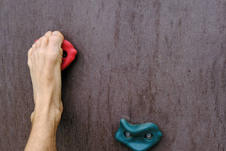 攀登奋斗人类赤脚就像一只手抓着攀爬的人造攀岩墙,为生存而奋斗的