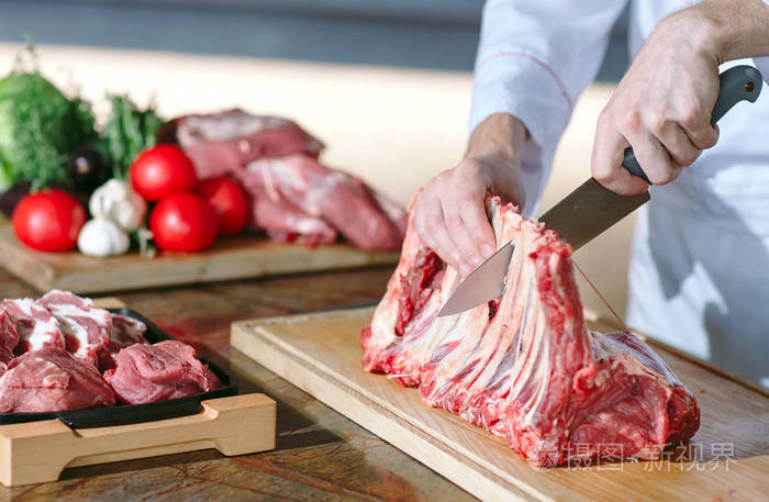 在一家餐馆里一个厨师用刀切肉