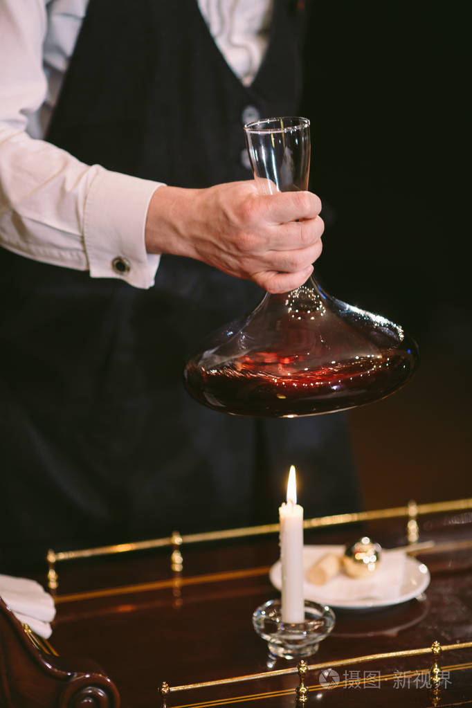 斟酒师把红酒倒入醒酒器