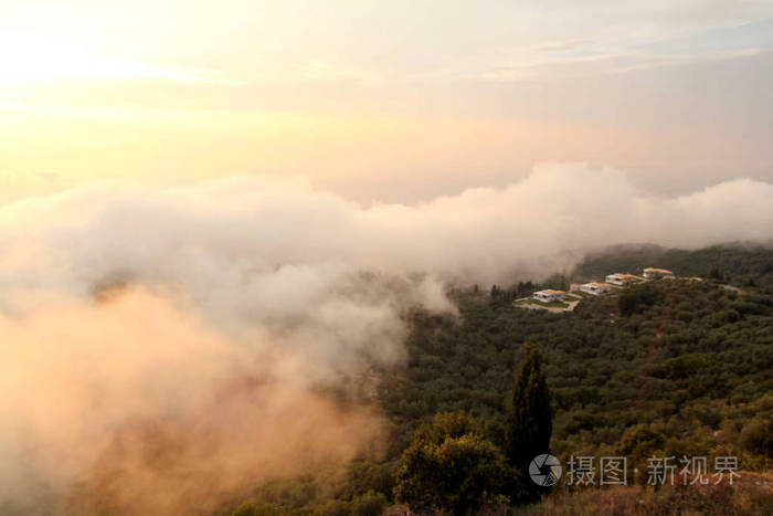 天空云彩结构优美，山峦景观日落时雾气缭绕，天边自然环境优美。令人惊叹的日出全景图显示太阳光穿过云层在山上。