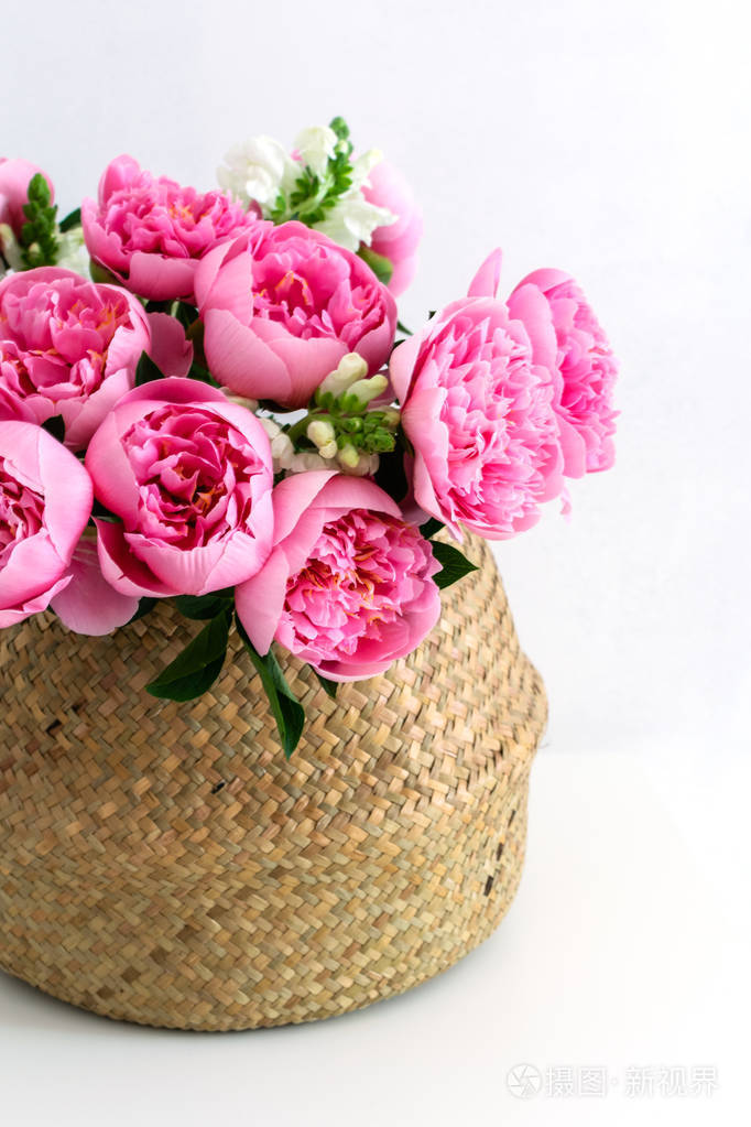 一束美丽的粉红色牡丹花放在草篮里