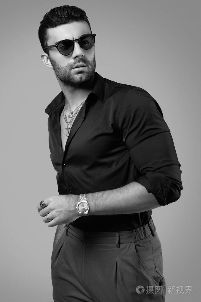 一个皮肤黝黑皮肤黝黑漂亮的时髦男人穿着黑衬衫戴着眼镜