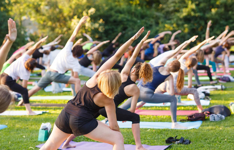 一大群成年人在公园外上瑜伽课图片