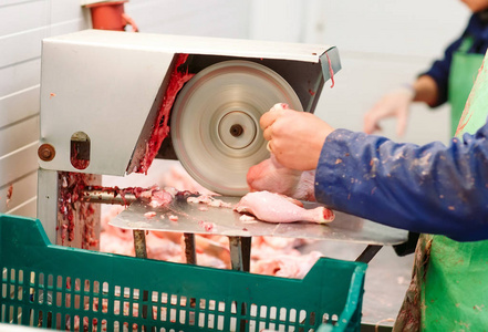 一个穿着制服的男雇员在锯肉照片
