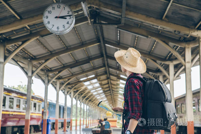 背包客站在火车站的钟下旅游