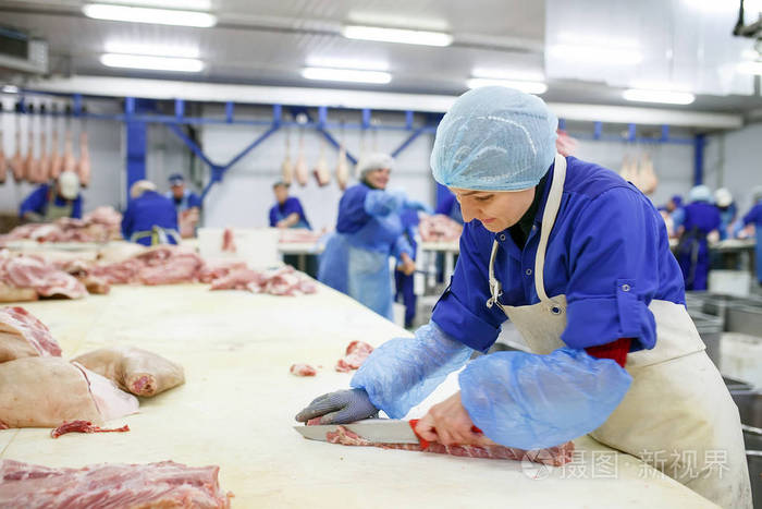 在屠宰场切肉肉店里切猪肉的屠夫