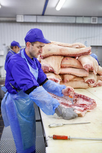 肉店里切猪肉的屠夫.照片