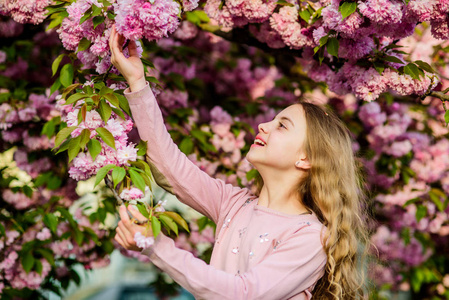 公园和花园.春花盛开的小女孩.享受阳光明媚的花香照片
