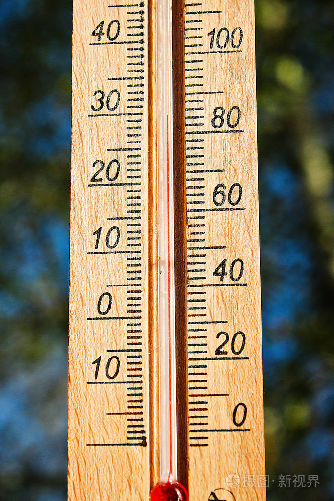 在阳光明媚的夏日里显示30度高温的温度计