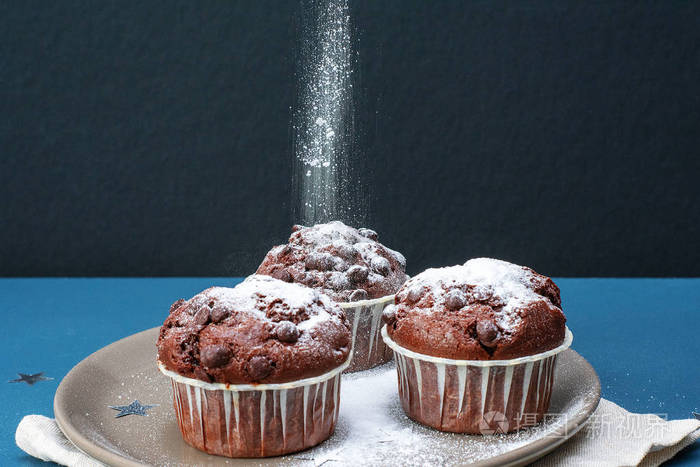 在绿松石桌子上的巧克力蛋糕上撒糖