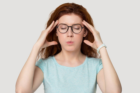 紧张的红发女人闭上眼睛呼吸做减压运动照片
